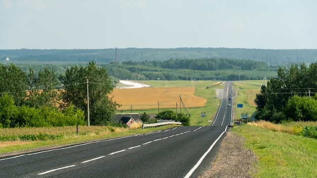 Vista panorámica de una larga carretera asfaltada vacía en una zona montañosa La sinuosa carretera vacía se adentra en la distancia más allá del horizonte