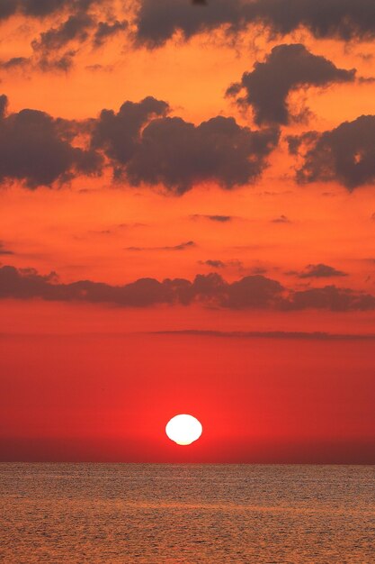 Foto vista panorámica del mar contra un cielo dramático durante la puesta de sol