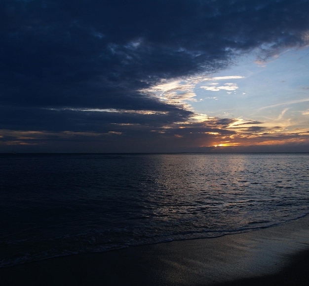 Foto vista panorámica del mar contra un cielo dramático durante la puesta de sol