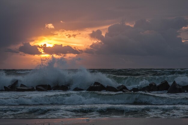 Foto vista panorámica del mar contra el cielo nublado durante la puesta de sol