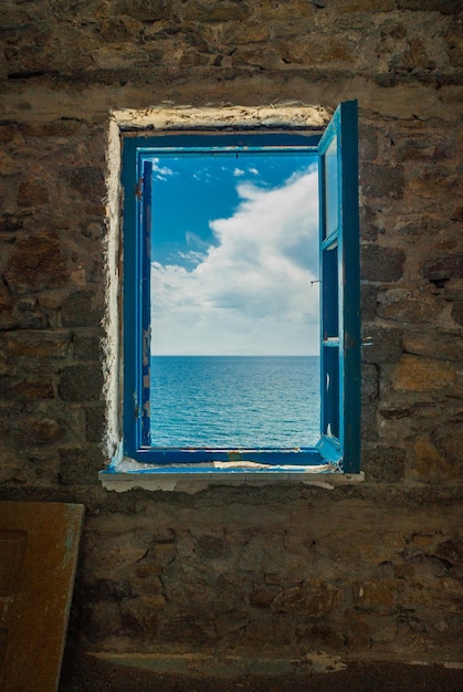 Vista panorámica del mar contra el cielo nublado visto a través de la ventana