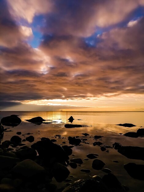 Vista panorámica del mar contra el cielo durante la puesta de sol con cálidos colores dorados