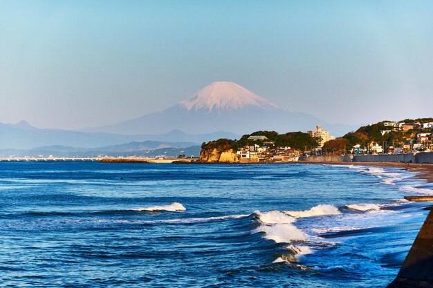 Foto vista panorámica del mar y las montañas cubiertas de nieve contra un cielo despejado