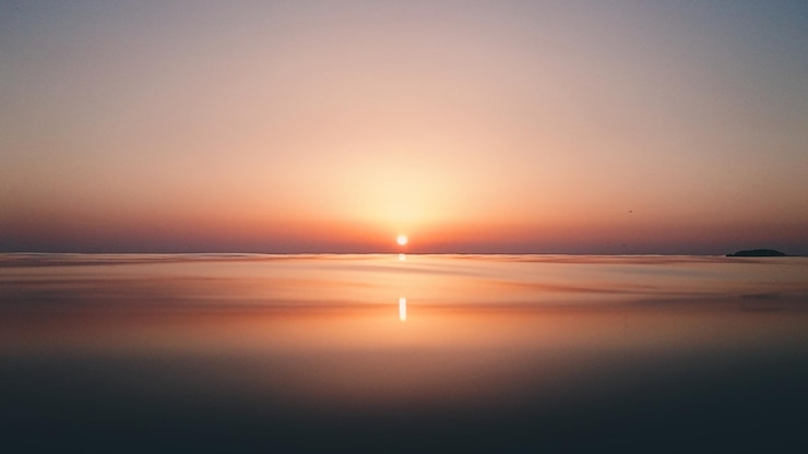 Foto vista panorámica del mar tranquilo contra el cielo despejado durante la puesta de sol