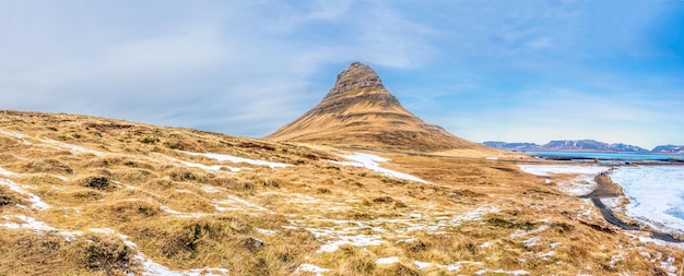 Vista panorámica de la montaña Kirkjufell, el punto de referencia más popular de la congelación fría de Islandia