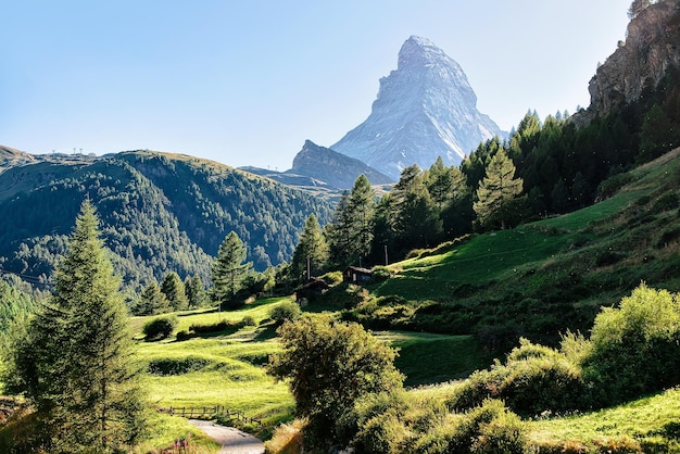 Vista panorámica de la montaña Matterhorn y el valle verde con chalets suizos tradicionales, Zermatt, Suiza en verano.