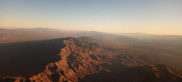 Foto vista panorámica de las montañas contra un cielo despejado durante la puesta de sol