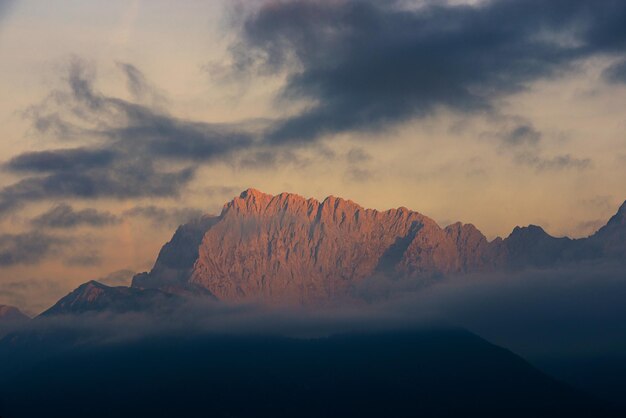 Foto vista panorámica de las montañas contra un cielo nublado durante la puesta de sol