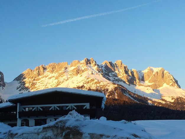 Foto una vista panorámica de las montañas cubiertas de nieve contra un cielo azul claro