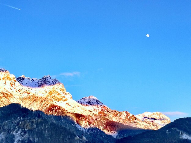 Una vista panorámica de las montañas cubiertas de nieve contra un cielo azul claro