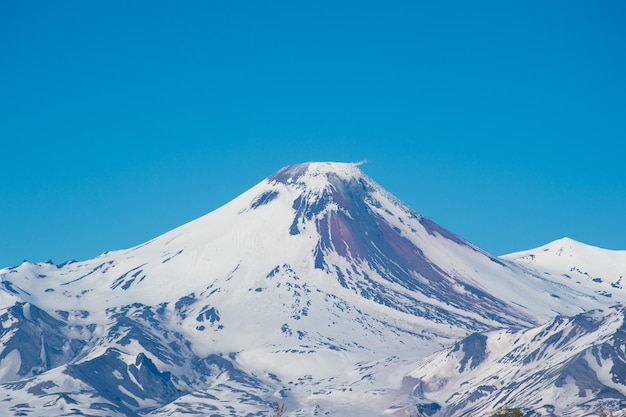Una vista panorámica de las montañas cubiertas de nieve contra un cielo azul claro
