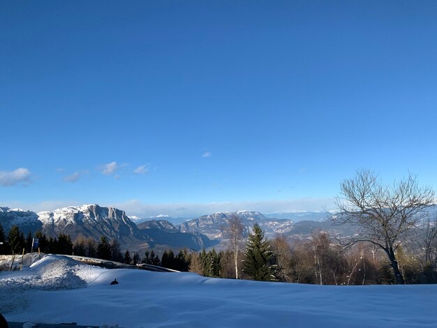 Foto una vista panorámica de las montañas cubiertas de nieve contra un cielo azul claro