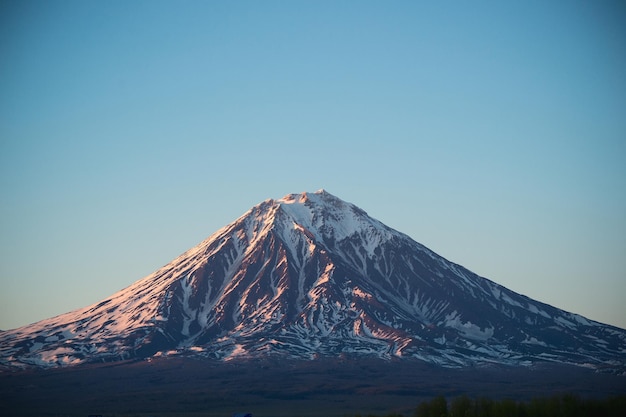 Una vista panorámica de las montañas cubiertas de nieve contra un cielo azul claro
