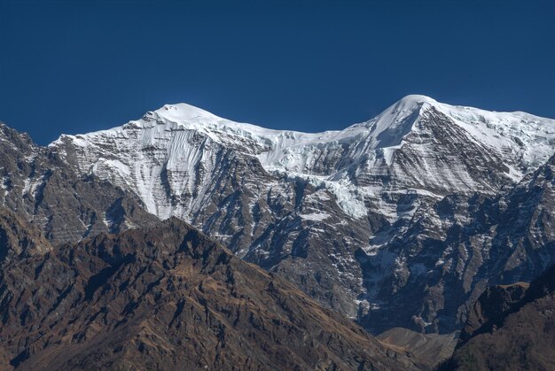 Foto una vista panorámica de las montañas cubiertas de nieve contra un cielo azul claro