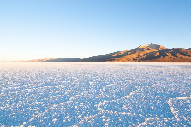 Una vista panorámica de las montañas cubiertas de nieve contra un cielo azul claro