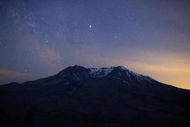 Foto vista panorámica de las montañas cubiertas de nieve contra el cielo nocturno