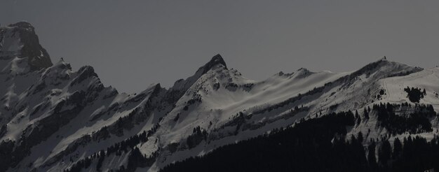 Foto vista panorámica de las montañas cubiertas de nieve contra el cielo