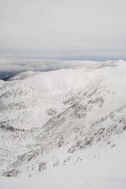 Foto vista panorámica de las montañas cubiertas de nieve contra el cielo