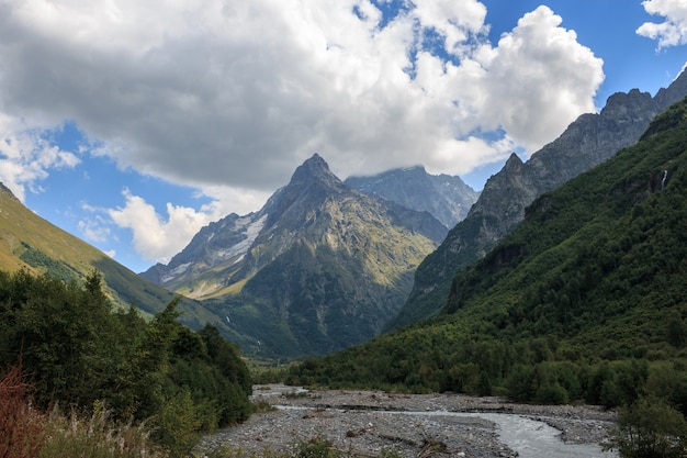 Vista panorámica de las montañas con escena de río en el parque nacional de Dombay, Cáucaso, Rusia. Paisaje de verano, clima soleado y día soleado.