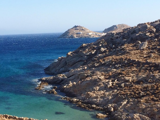 Vista panorámica de las montañas en la orilla del mar contra un cielo despejado