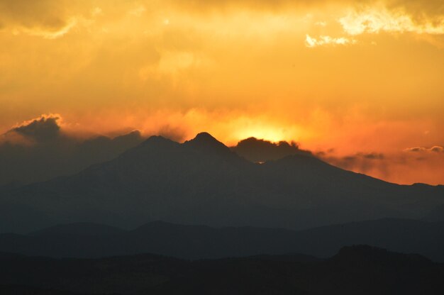 Foto vista panorámica de las montañas en silueta contra un cielo dramático