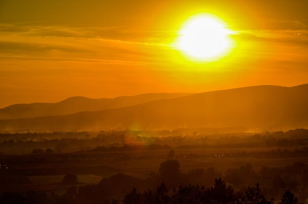 Vista panorámica de las montañas en silueta contra el cielo naranja