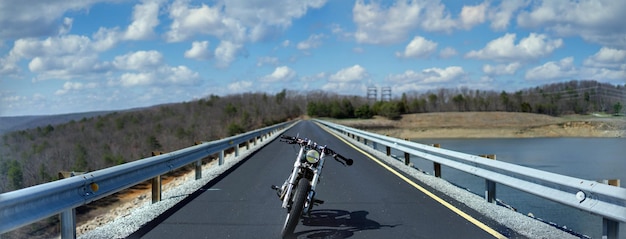 Foto vista panorámica de una motocicleta estacionada en el puente sobre el río contra el cielo