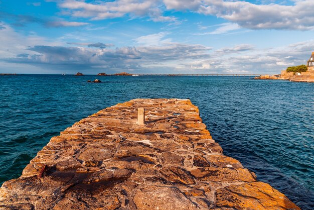 Vista panorámica del muelle de piedra en el paseo marítimo por la noche en verano en Bretaña, Francia