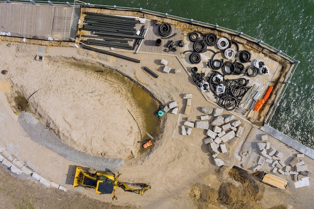 Vista panorámica del muelle del servicio de reparación en tubos negros de plástico que se encuentran en el muelle de madera que drenan