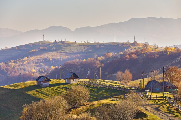 Vista panorámica de la noche nublada soleada de otoño en las montañas hermoso paisaje de colinas al atardecer pendientes prados campos casa de la aldea camino de tierra increíble escena rural de otoño cordillera de los Cárpatos