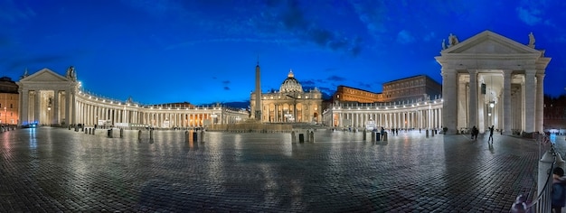 Vista panorámica por la noche de la plaza de San Pedro en Roma, Italia, con las enormes columnatas dóricas, el antiguo obelisco egipcio y la Basílica