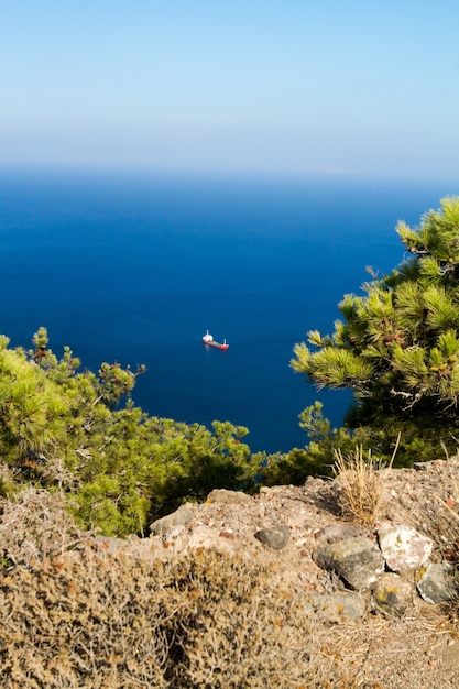 Vista panorámica del océano azul y velero desde el acantilado