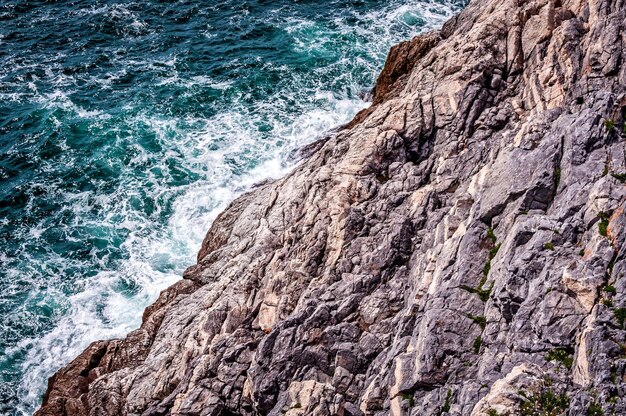 Foto vista panorámica de las olas del mar golpeando contra la formación rocosa