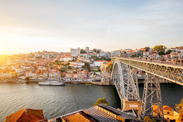 Vista panorámica del paisaje de la ciudad vieja con el río Duero y el famoso puente de hierro en la ciudad de Oporto durante la puesta de sol en Portugal