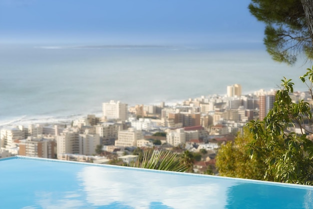 Vista panorámica de la piscina infinita con vista a Sea Point en Ciudad del Cabo Sudáfrica con fondo oceánico Escritorio de lujo al aire libre en la azotea en un hotel de condominio Cityscape skyline de la ciudad