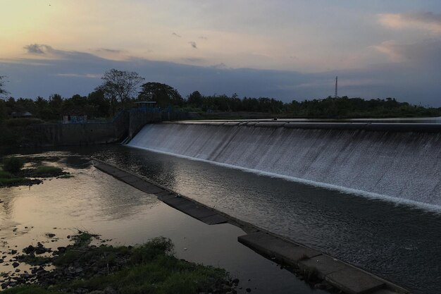 Vista panorámica de la presa por el río contra el cielo