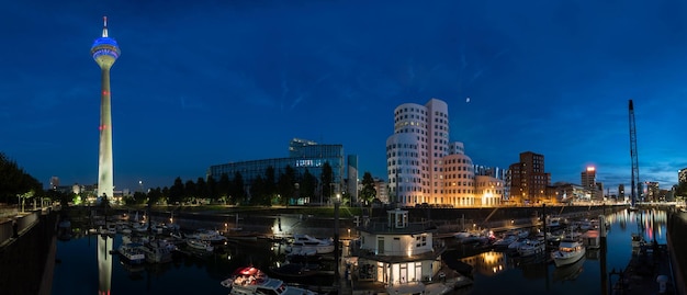 vista panorámica del puerto de medios con botas por la noche en dusseldorf. ideal para diseños de sitios web y revistas