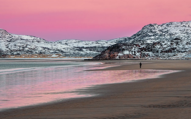 Vista panorámica de la puesta de sol de invierno con un increíble color magenta sobre el fiordo. Vista del invierno Teriberka. Rusia.