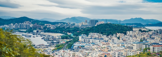 Vista panorâmica superior da cidade de Sanya em Hainan, com casas locais e hotéis e edifícios de luxo. Paraíso de férias de verão na Ásia.