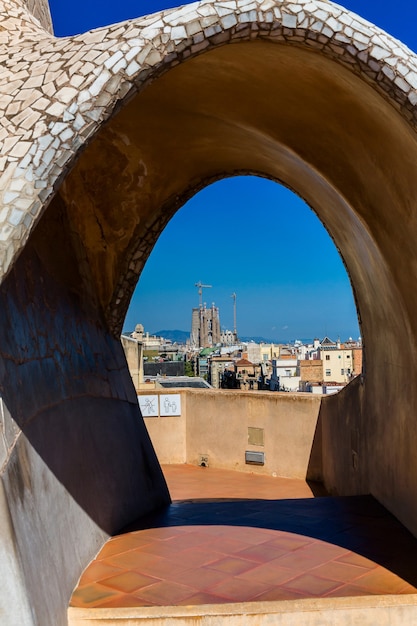 Vista panorámica superior del paisaje de Barcelona desde la azotea de la Casa Milá, también conocida como La Pedrera, diseñada por Antonio Gaudi. Europa, Barcelona, España. Sagrada de Familia al fondo.