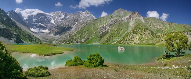 Vista panorámica de un valle de montaña con un lago en las montañas de Tayikistán