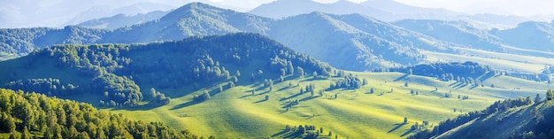 Vista panorámica de un valle pintoresco en las colinas y los prados verdes claros de la tarde