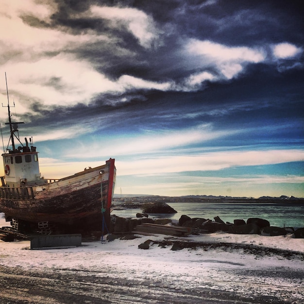Foto vista panorámica de un viejo barco en la costa en invierno