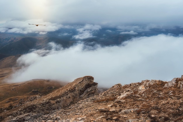 Vista para a montanha nevoenta do penhasco em altitude muito alta Paisagem alpina cênica com belas rochas afiadas e couloirs no nascer do sol Belas paisagens na borda do abismo com pedras afiadas