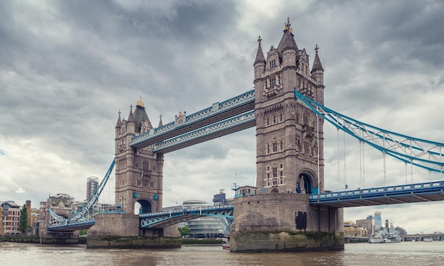 vista para a ponte da torre no rio tâmisa em um dia nublado com céu de tempestade em londres. ideal para layouts de sites e revistas