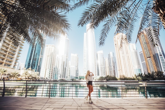 Vista para o lago brilhante e limpa com vista para uma cidade urbana emirates golf lifestyle country. Fotografia de senhora russa na cidade com prédio alto nos arredores.