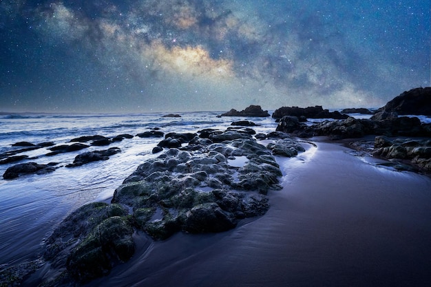 vista para o Oceano Pacífico e rochas à noite com fundo da Via Láctea