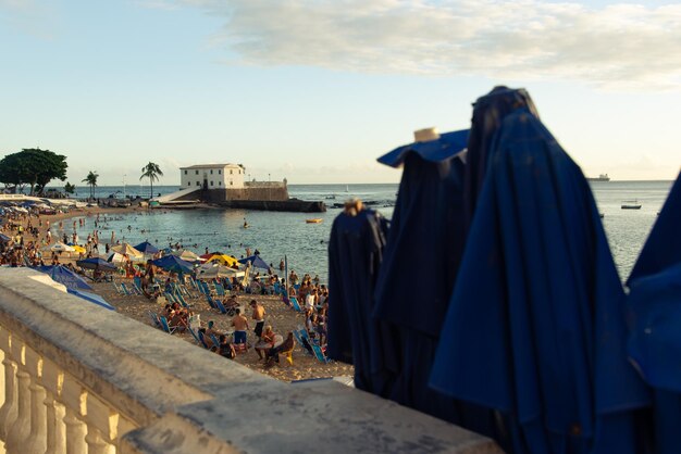 Vista de paraguas y el Fuerte de Santa María en el fondo en la playa de Porto da Barra en la ciudad de Salvador Bahia