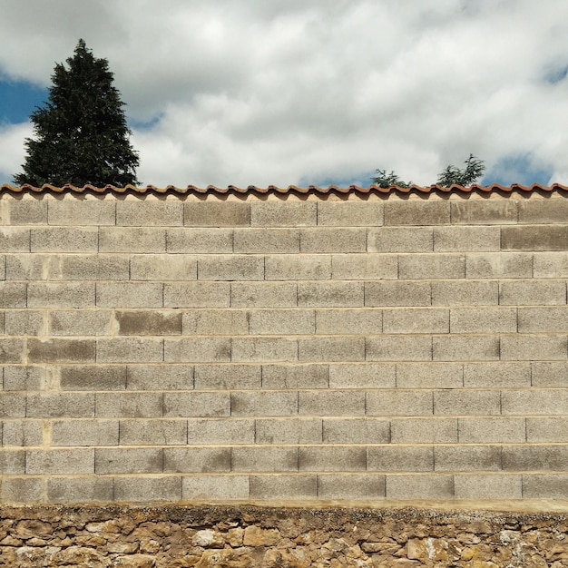 Foto vista de la pared de ladrillo contra el cielo nublado