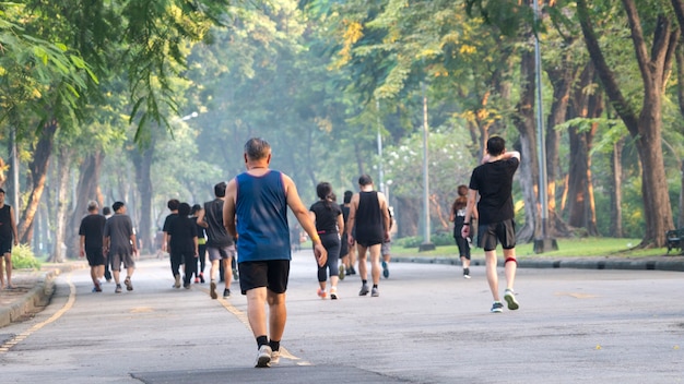 vista de la parte posterior de la gente corre y camina en el parque jardín peatonal